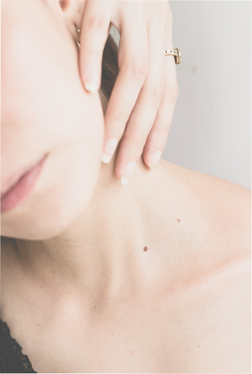 女性が右手で首の左側を触っている画像